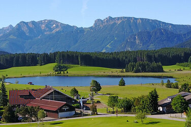 Urlaub auf einem Bauernhof mit wunderschönem Blick auf einen klaren See und mächtige Berge