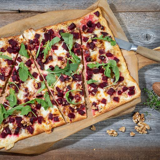 Leckerer Flammkuchen belegt mit Roter Bete überbacken mit dem Käse der Schönegger Käse Alm verfeinert mit frischen Basilikum Blättern