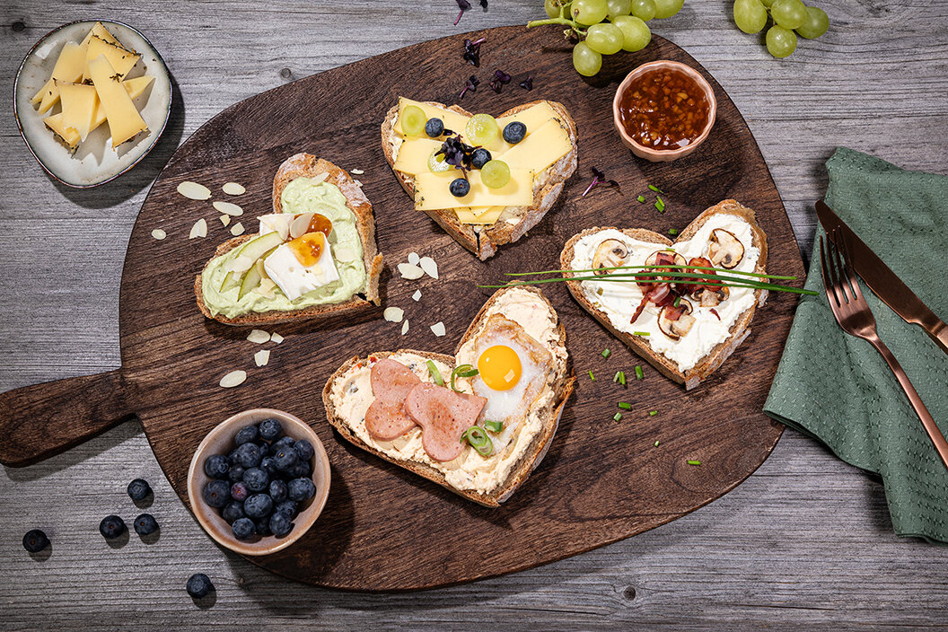 Brotzeit selber machen. Brotzeit in Herzen gestochen. Verschieden belegte Brote