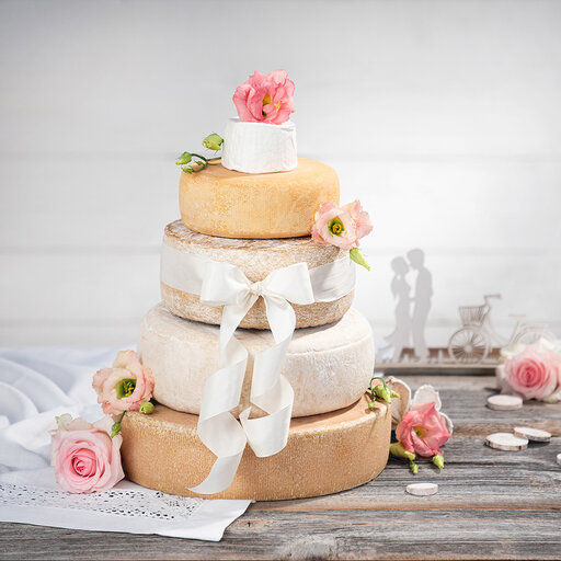 Hochzeitstorte aus Käselaiben verziert mit Schleifen und Blumen
