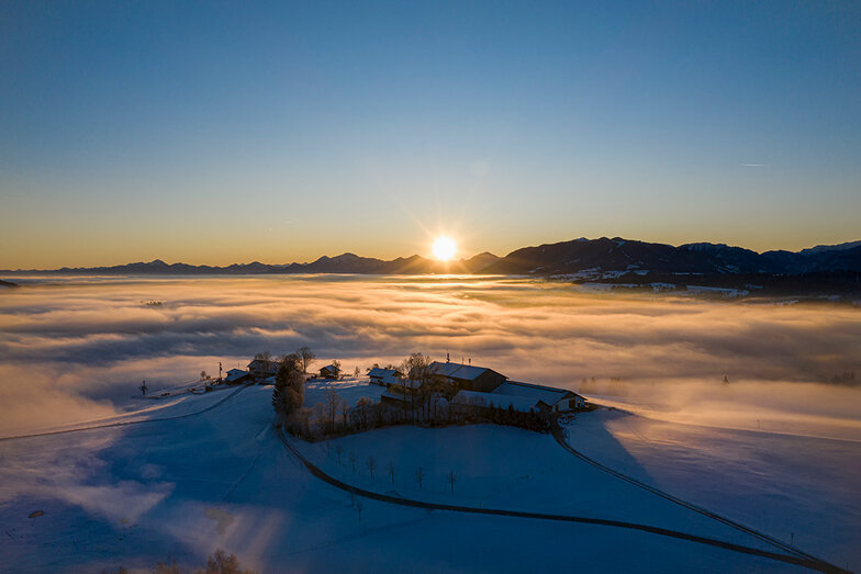 Sonnenaufgang in schöner Berglandschaft und vernebeltem und verschneiten Tal im Pfaffenwinkel 