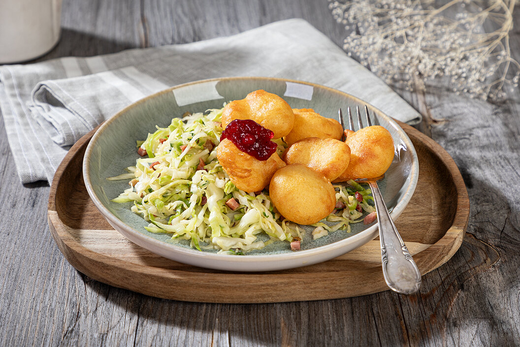 Kleine Käsekrapfen selber machen. Leckere Käsekrapferl auf einem Salat garniert mit Preiselbeermarmelade. 