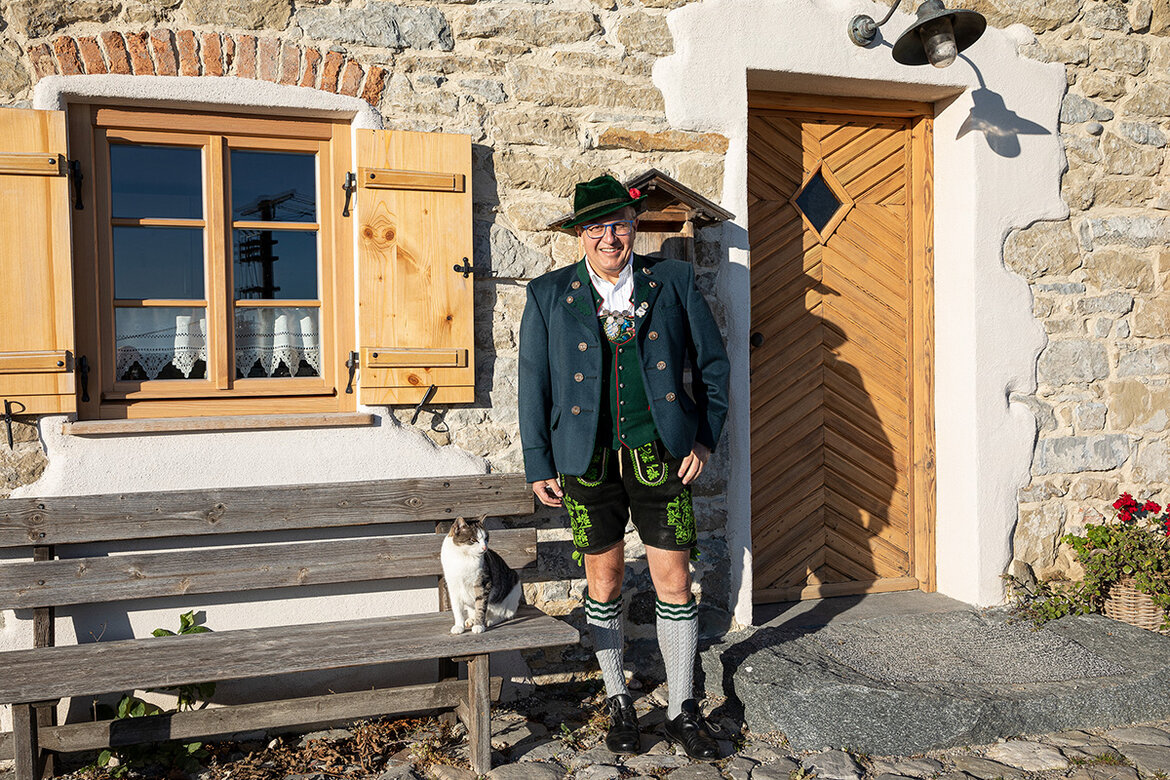 Sepp Krönauer vor seinem Elternhaus und Bauernhofhaus in Schönegg in Rottenbuch gekleidet in traditioneller Tracht 