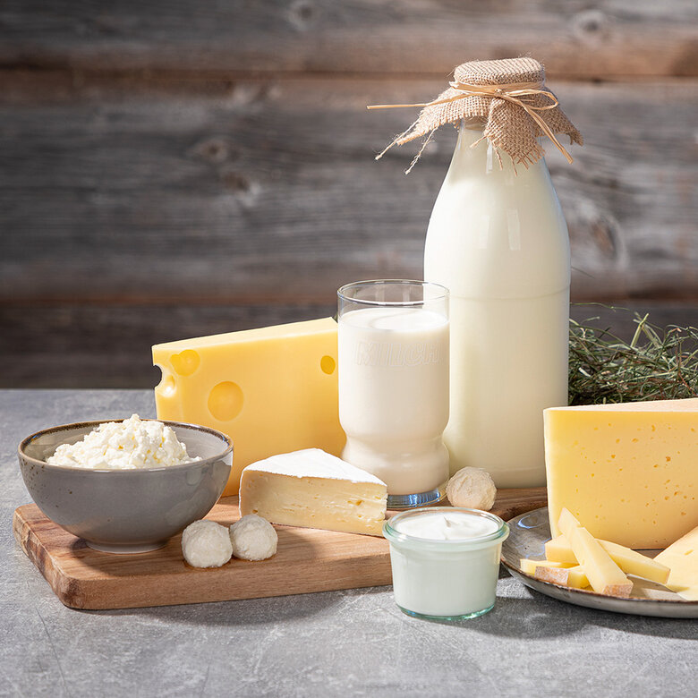 leckere Spezialitäten aus Bergbauern-Heumilch wie Käse, Milch und sonstigen leckeren Schmankerl auf einem urigen schönen Holztisch