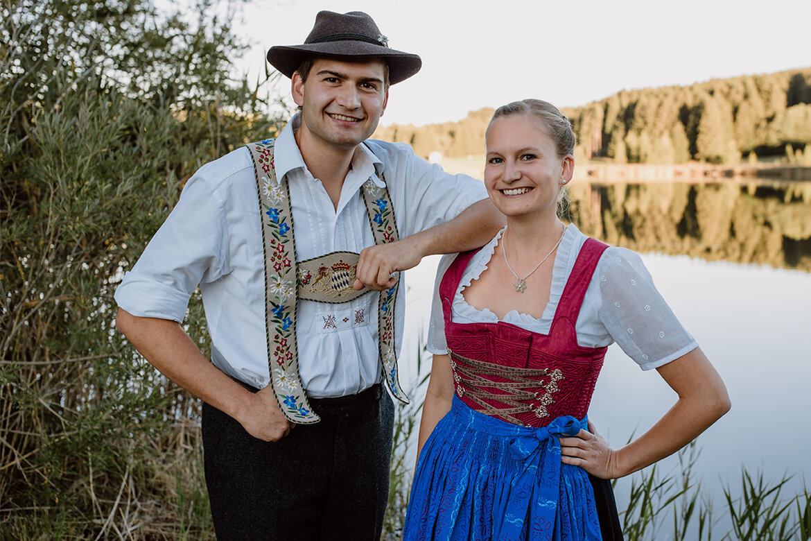 Inhaber Katharina und Andreas der Schönegger Käse-Alm vor einem wunderschönen See mit Schilf