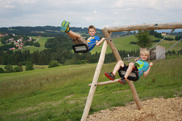 große Schaukel auf dem Spielplatz in Schönegg mit einem herrlichen Ausblick in die Berge