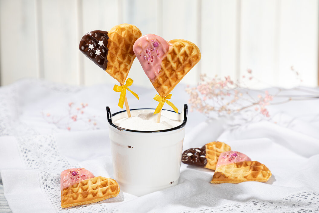 Valentinstags Rezept süß. Leckere Waffeln in Herzform mit Schokoladigen Ecken bestreut mit Streuseln. 