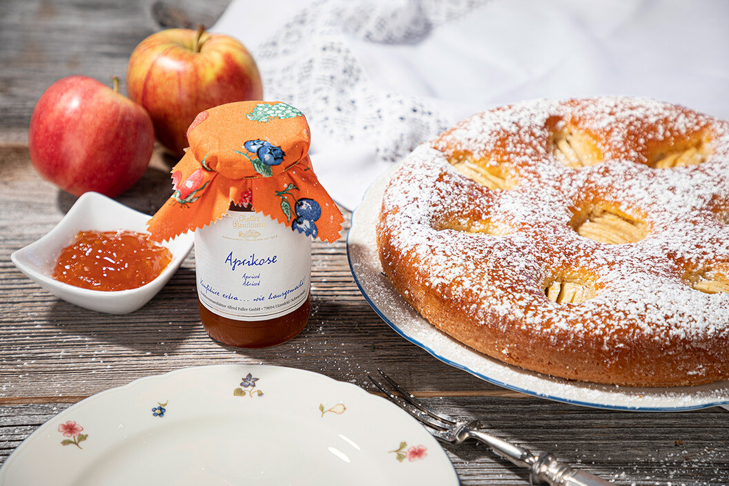 feine Aprikosen-Marmeladen neben einem frisch gebackenen Apfelkuchen