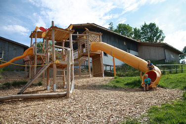 großer Spielplatz mit einer gelben Rutsche und vielen Klettermöglichkeiten in herrlicher Lage hinter der Schönegger Käse-Alm in Rottenbuch