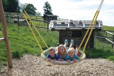 große Vogelschaukel auf einem Spielplatz in Schönegg hinter der urigen Käsealm