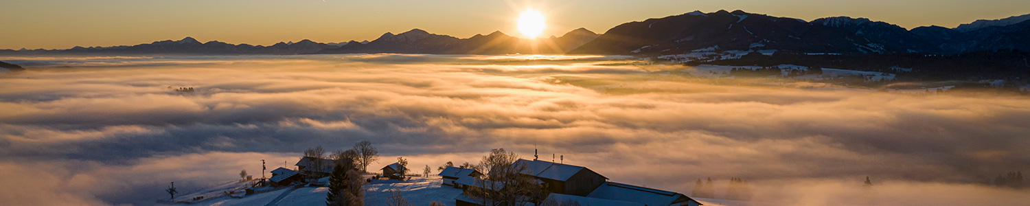 Sonnenaufgang in gigantischer Berglandschaft und das Tal Schönegg im Nebel versunken